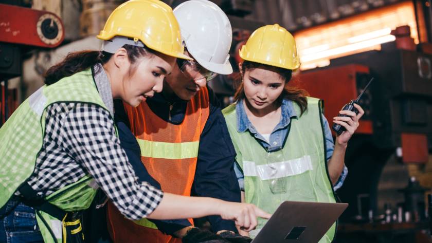 Asian engineer foreman training trainee working on factory system