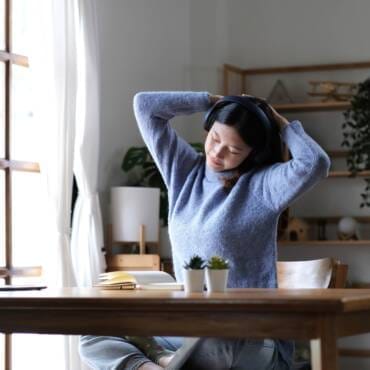 Asian woman raise hand while learning online with tablet at home