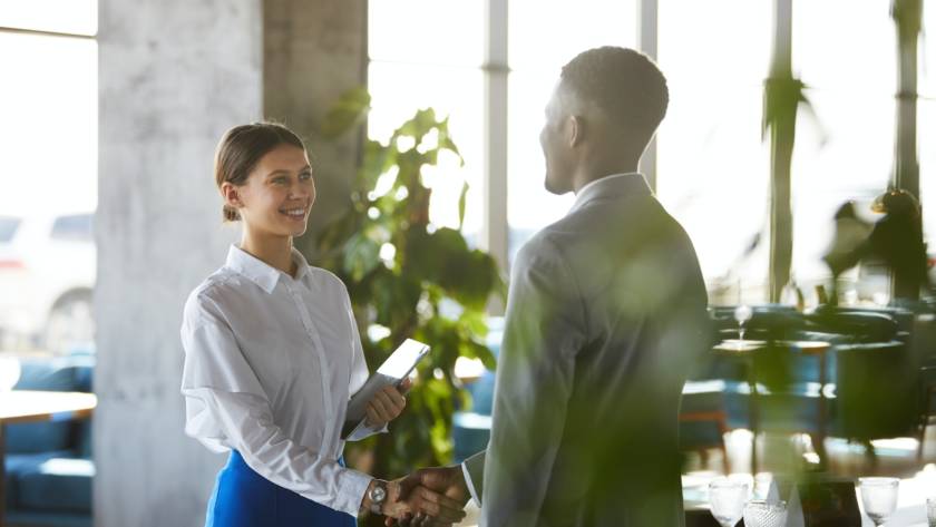 Pretty business lady shaking hand of business partner