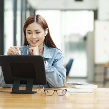 Young female student learning online using tablet.
